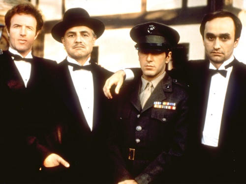 Členové mafiánské rodiny Corleonových.Zleva James Caan jako Sonny Corleone, Marlon Brando jako Don Vito Corleone, Al Pacino jako Michael Corleone a John Cazale jako Fredo Corleone.